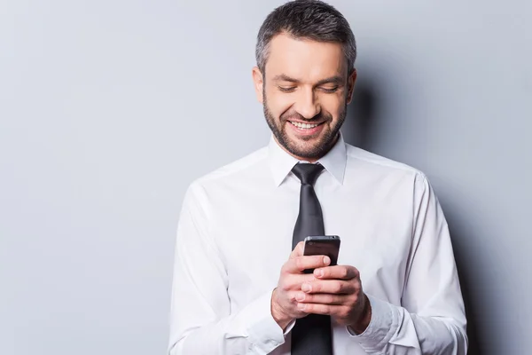 Zralý muž v košili a kravatu, drží mobilní telefon — Stock fotografie