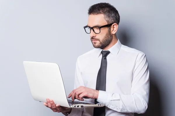 Uomo in camicia e cravatta al lavoro sul computer portatile — Foto Stock