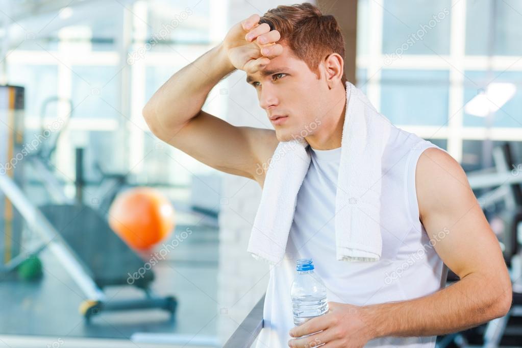 Man carrying towel on shoulders in gym