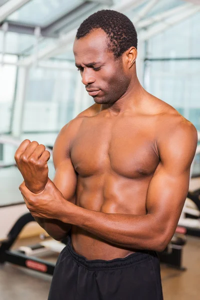 Hombre africano frustrado tocándose el brazo —  Fotos de Stock