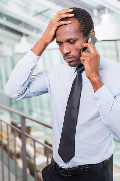 Frustrated African talking on  phone