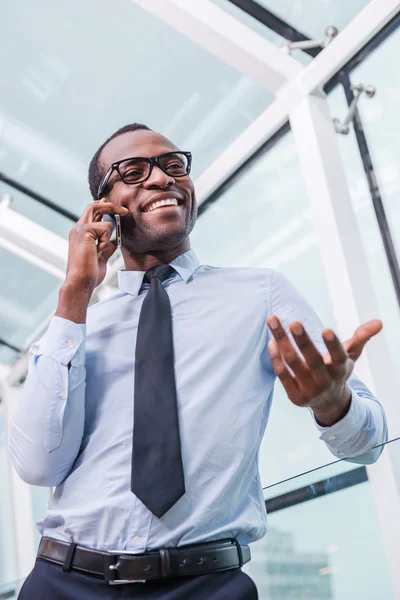 Afrikansk man i skjorta och slips talar i mobiltelefon — Stockfoto