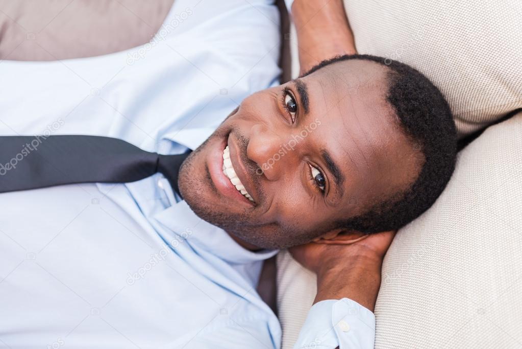 African man lying on couch