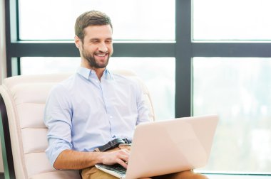 Dizüstü bilgisayarda çalışan adam