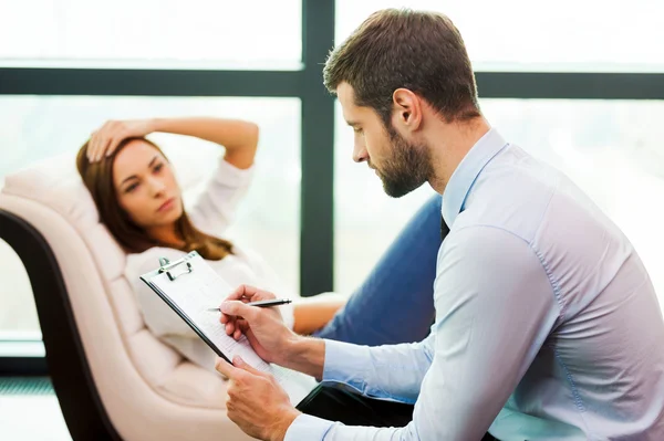 Gefrustreerd vrouw zitten op de stoel en bezit hand — Stockfoto