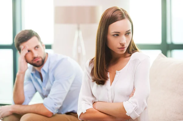 Depressive Frau und Mann sitzen hinter ihr — Stockfoto