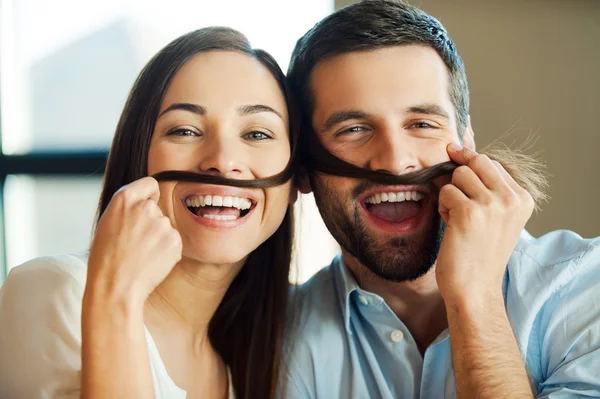 Älskande par att göra falska mustascher — Stockfoto