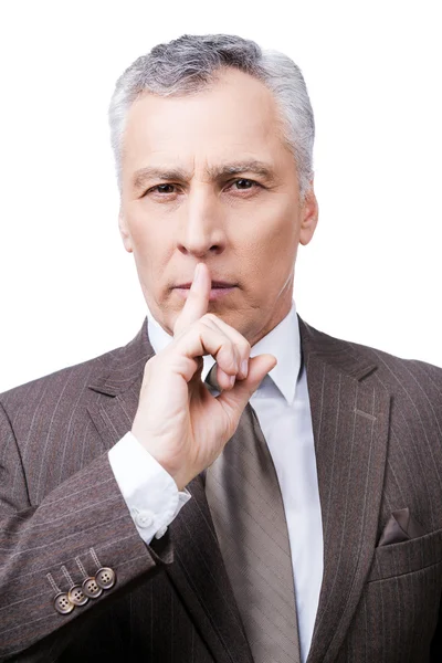 Mature man in formalwear holding finger on lips — Stock Photo, Image