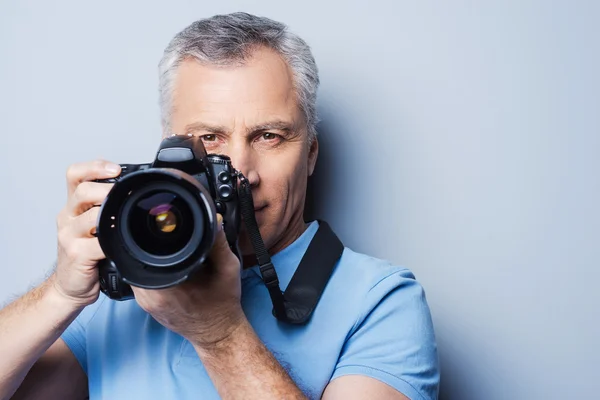 Hombre mayor en camiseta sosteniendo cámara —  Fotos de Stock