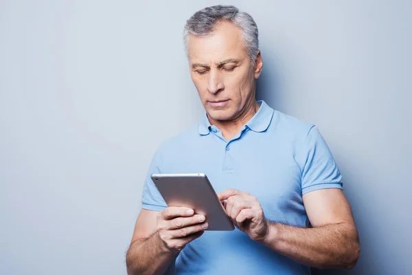 Senior homme travaillant sur sa tablette numérique — Photo