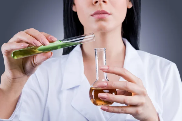 Female doctor in white uniform holding flasks — Stock Photo, Image