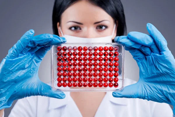 Kvinnliga läkare håller micro antikroppnivåns plattan — Stockfoto