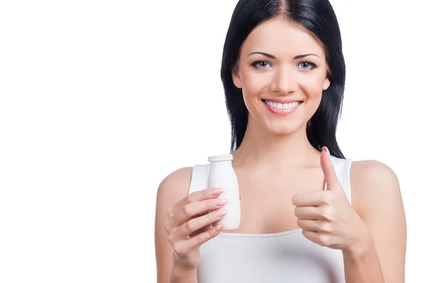 Woman holding bottle and gesturing thumb up — Stock Photo, Image