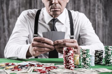 Poker masasında oturan ciddi üst düzey adam