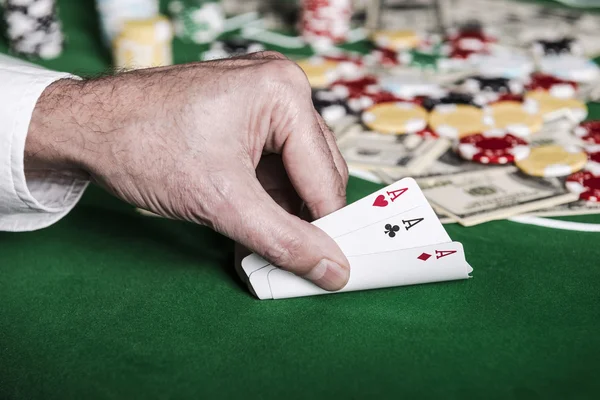 Hand tonen zijn kaarten op de pokertafel — Stockfoto