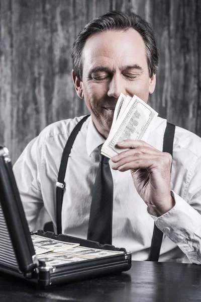 Senior man in shirt ruiken geld — Stockfoto