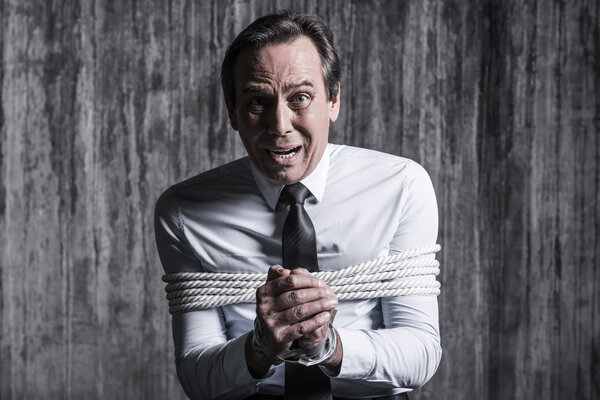 Shocked tied up businessman asking help