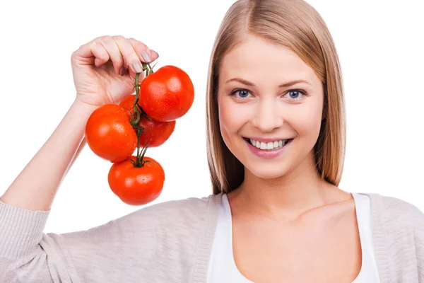 Mladá žena hospodářství rajčata — Stock fotografie