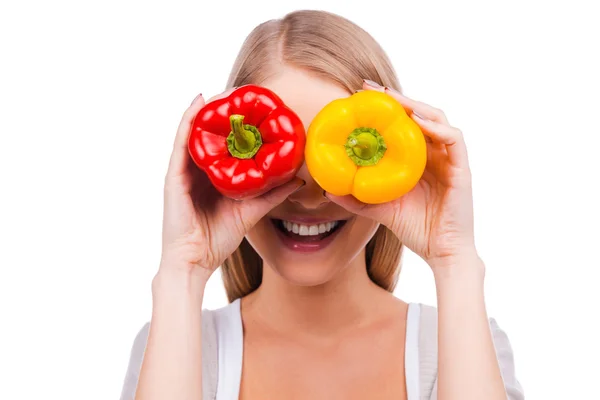 Femme couvrant ses yeux avec des poivrons colorés — Photo