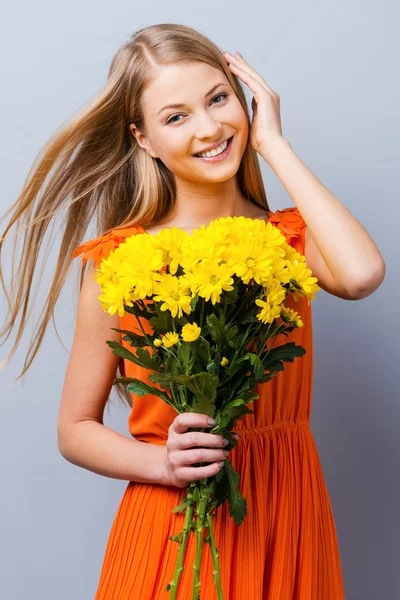 Žena v hezké šaty drží kytici květin — Stock fotografie