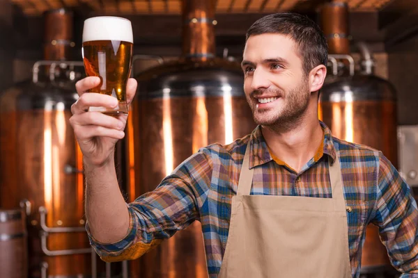 Cervecero en delantal sosteniendo vaso con cerveza —  Fotos de Stock