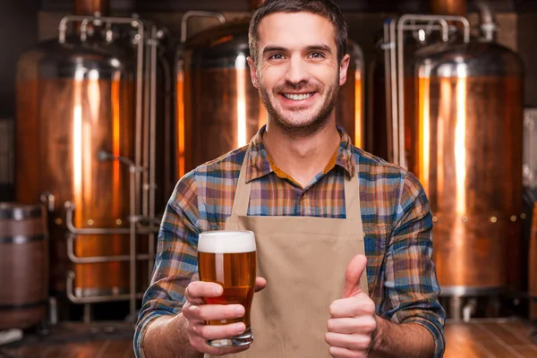 Cervecero en delantal sosteniendo vaso con cerveza — Foto de Stock