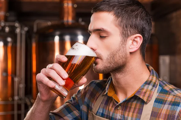 Brewer in apron tasting fresh beer — Stock Photo, Image