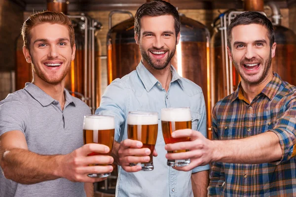 Jovens homens esticando óculos com cerveja — Fotografia de Stock