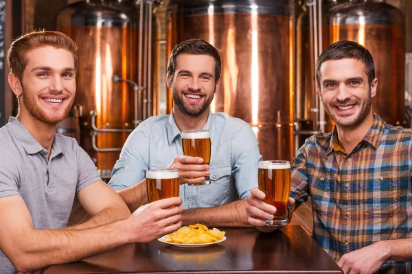 Young men holding glasses with beer — Stock Photo, Image