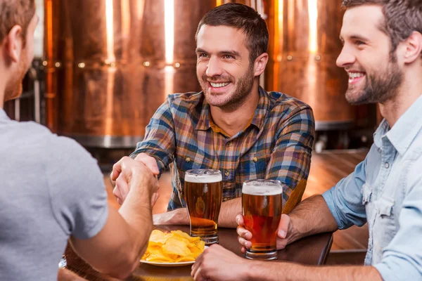 Young men sitting in beer pub — Stock Photo, Image