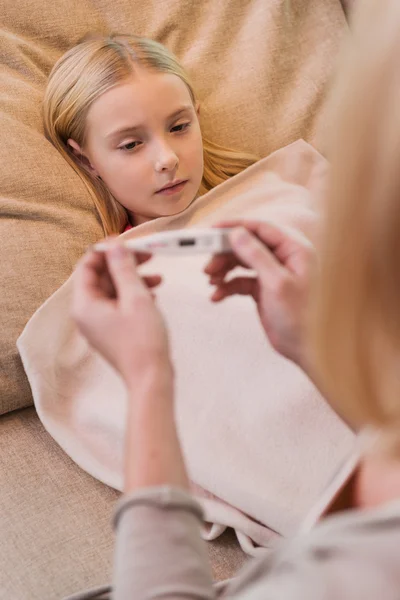 Mamma tittar på termometern nära sjuka dotter — Stockfoto