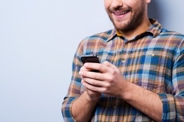 Cep telefonu tutan tişörtlü adam