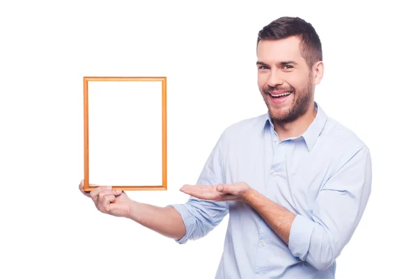 Young man holding picture frame — Stock Photo, Image