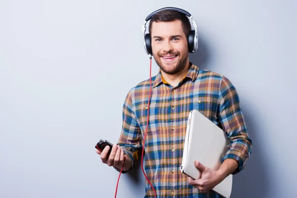 Homem em fones de ouvido segurando laptop — Fotografia de Stock