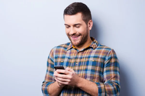 Muž v košili drží mobilní telefon — Stock fotografie