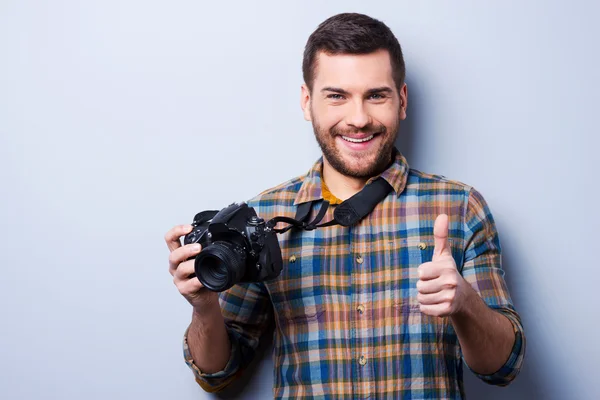 Mann hält Kamera und zeigt Daumen hoch — Stockfoto