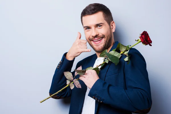 Hombre llevando rosa y gestos de teléfono móvil — Foto de Stock