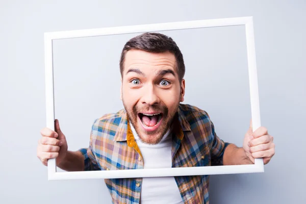 Mannen i skjortan håller bildramen — Stockfoto