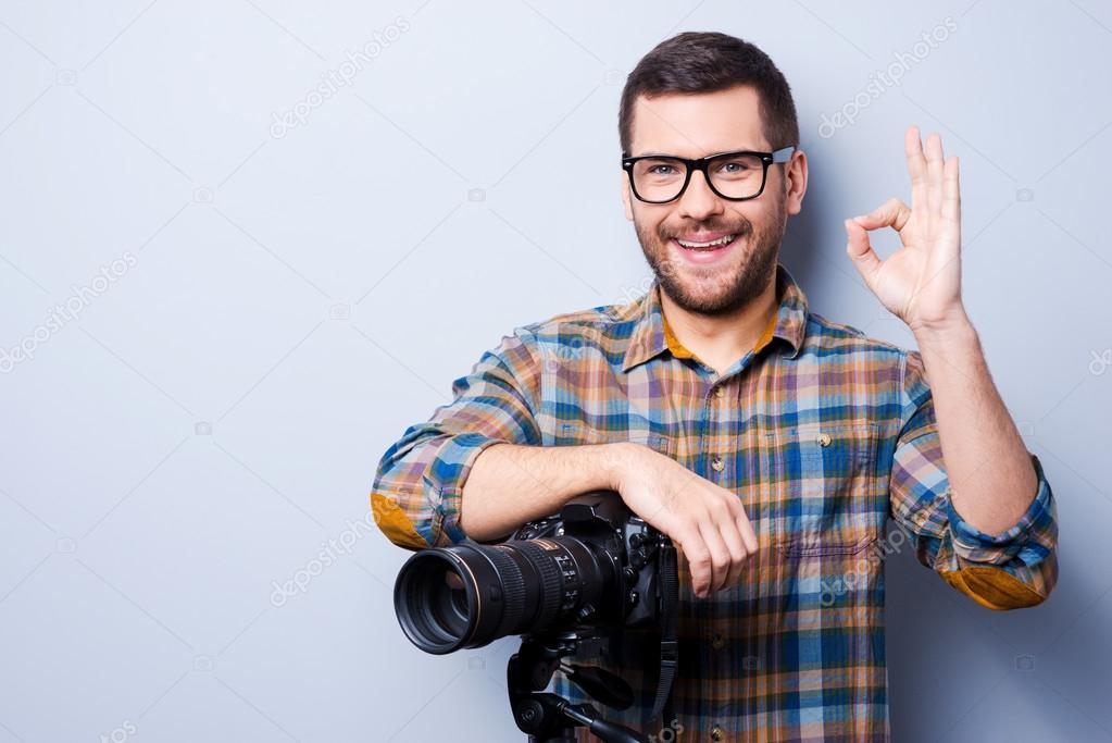 Man with camera gesturing OK