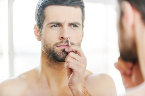 Man tweezing hair from nose — Stock Photo, Image