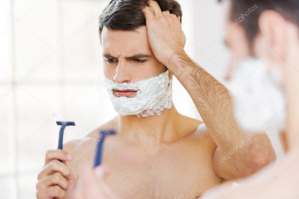 Man with shaving cream holding razor