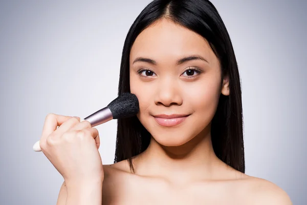 Mujer asiática sosteniendo cepillo de maquillaje — Foto de Stock