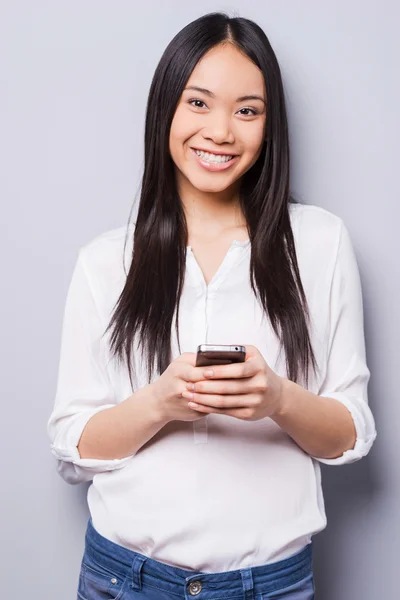 Mujer asiática sosteniendo teléfono móvil —  Fotos de Stock