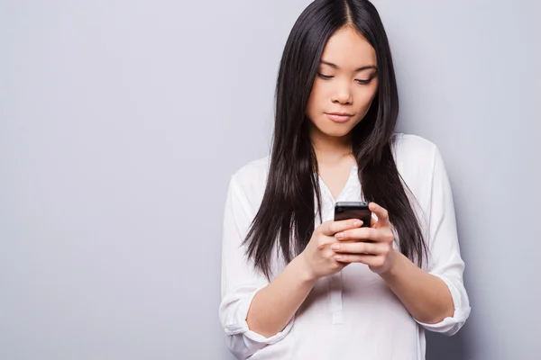 Mujer asiática sosteniendo teléfono móvil — Foto de Stock