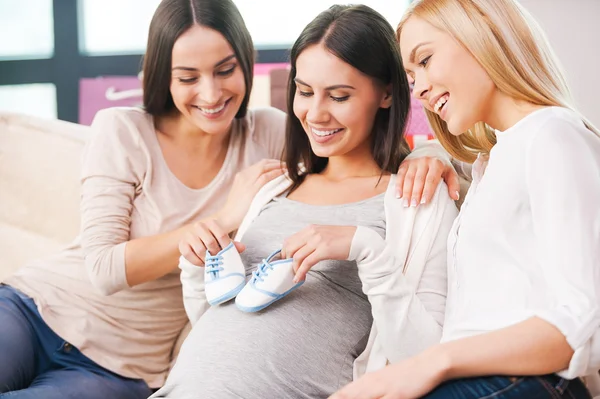 Femme enceinte tenant des chaussons de bébé — Photo