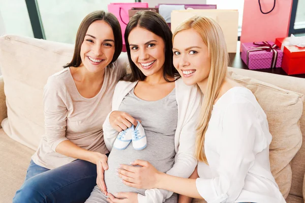 Femme enceinte tenant des chaussons de bébé — Photo