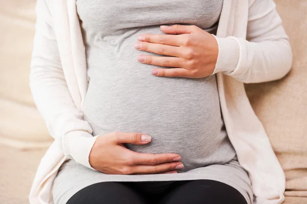 Pregnant woman touching her abdomen — Stock Photo, Image