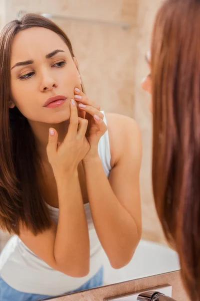 Mujer examinando su cara — Foto de Stock