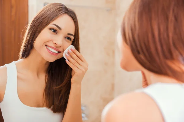 Mujer tocando la cara con esponja — Foto de Stock