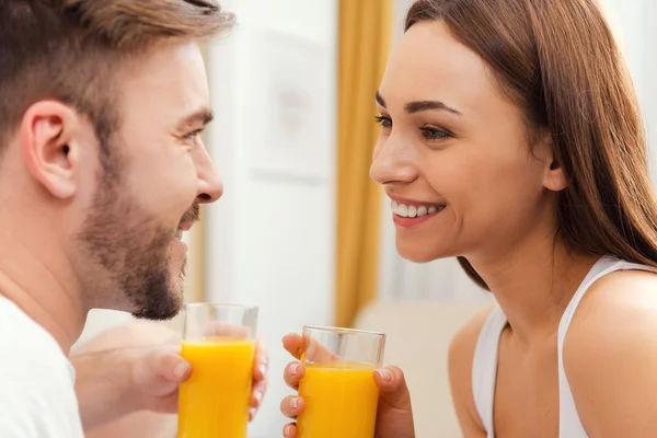 Pareja sosteniendo vasos de jugo de naranja —  Fotos de Stock